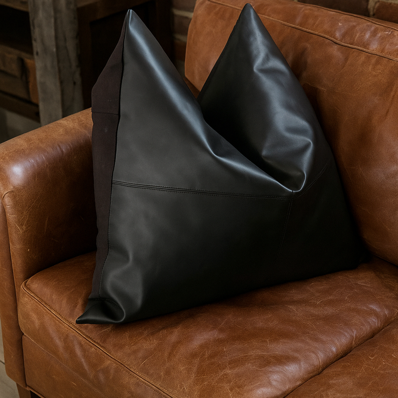 Black twist design leather cushion cover on a tan leather couch.