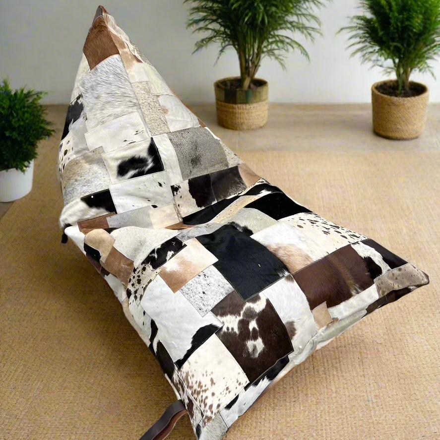 Boho triangular cowhide bean bag cover with patchwork of cream, coffee, chocolate, and brindle tones.