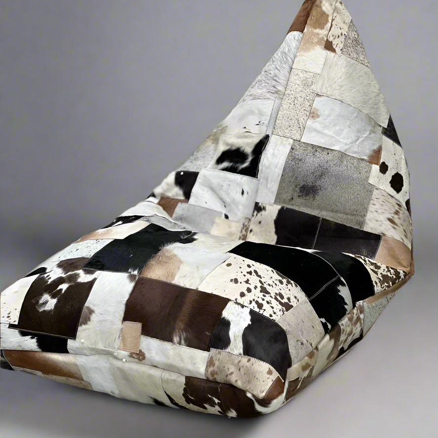Triangular cowhide bean bag cover with patchwork of cream, coffee, chocolate, and brindle tones.