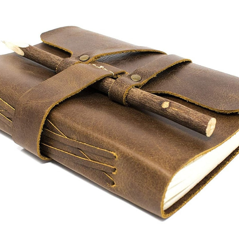 Vintage brown genuine leather journal with a rustic wood pencil secured by a leather strap.