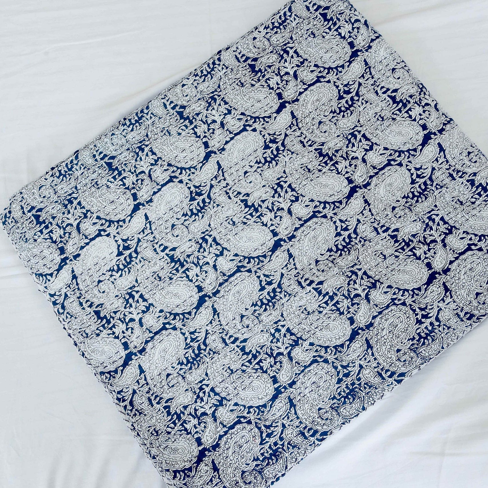 Folded Celestial Blue Kantha Quilt, King size, with white paisley pattern on 100% cotton fabric.