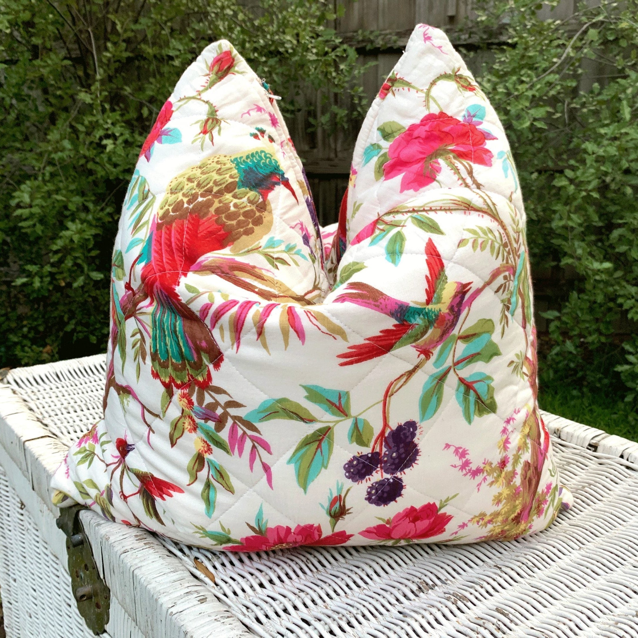 Handmade quilted cotton cushion cover with vibrant bird of paradise and floral print on white.