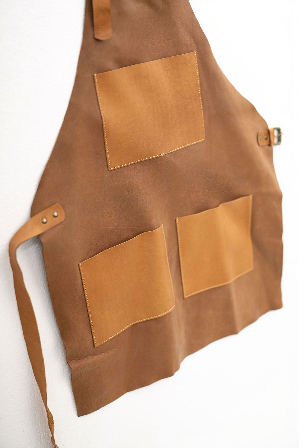 Durable tan leather apron with tool pockets for woodworking