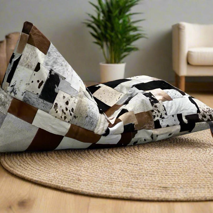 Boho triangular cowhide bean bag cover with patchwork of cream, coffee, chocolate, and brindle tones.
