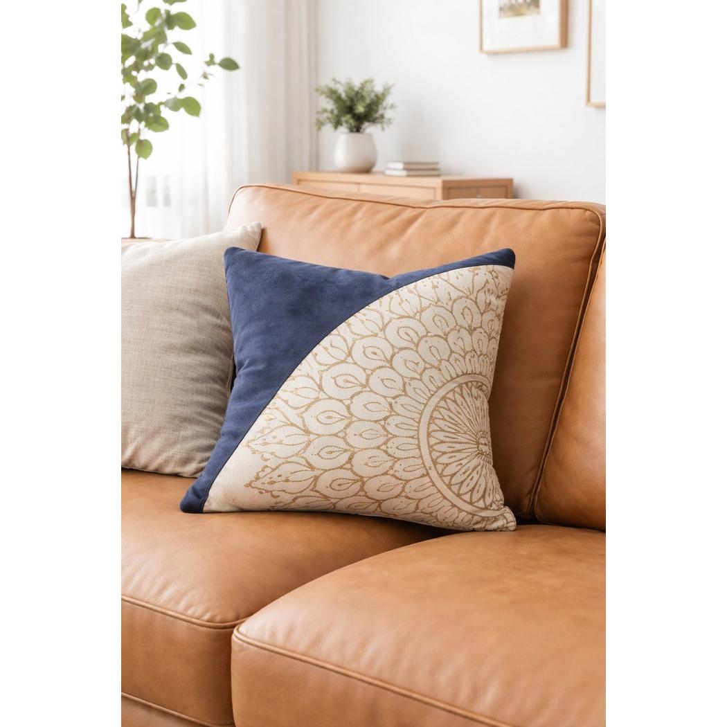 Blue & cream mandala print cowhide leather cushion cover on a tan leather sofa.