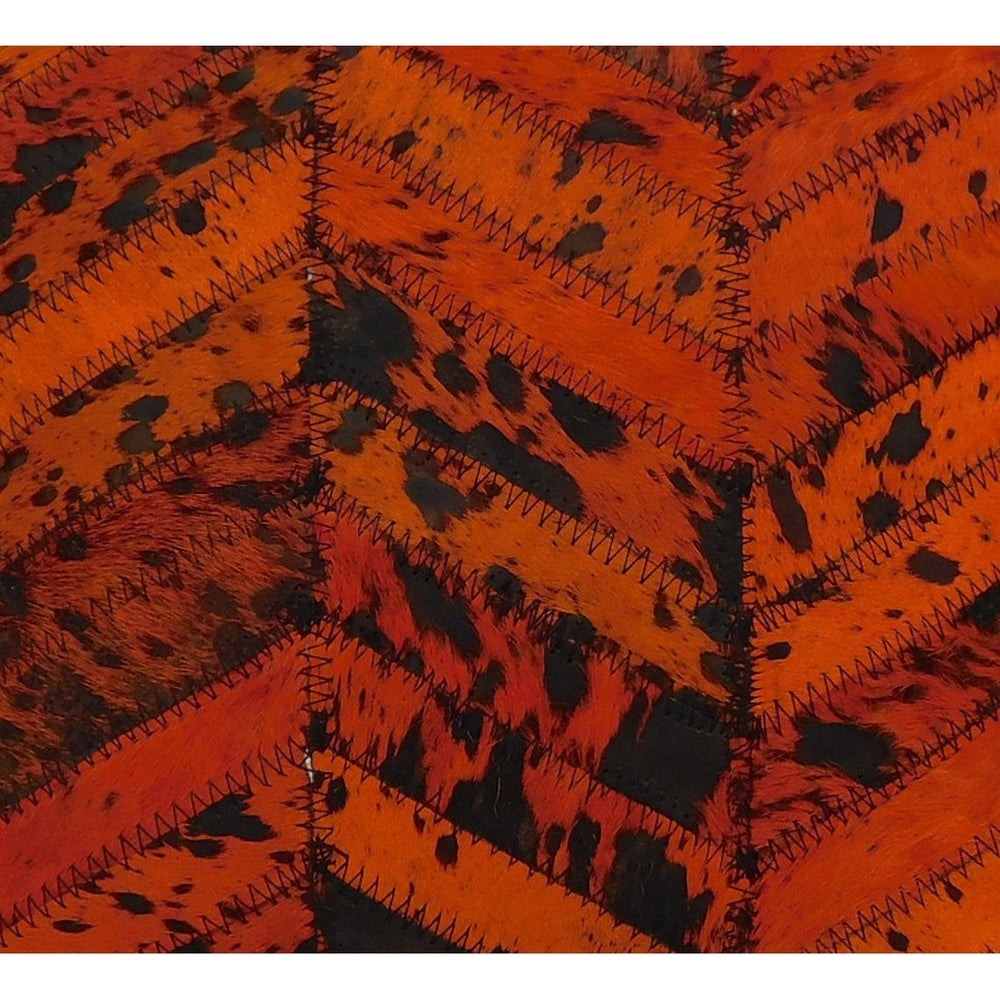 Close-up of a 40x40cm luxury orange and black patchwork cowhide cushion cover with visible stitching.