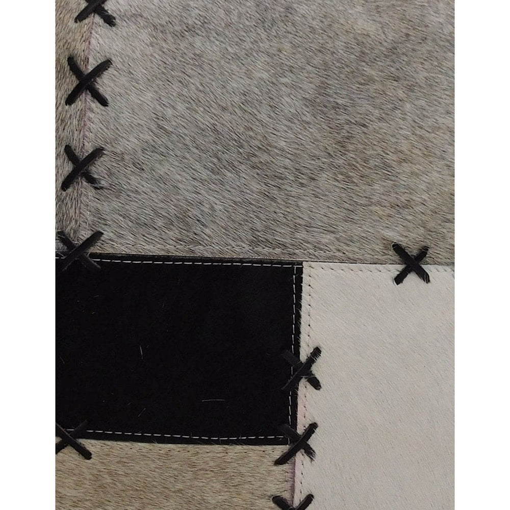 45x45cm cowhide cushion cover with black, grey, and cream patchwork, featuring bold X-stitch lacing.