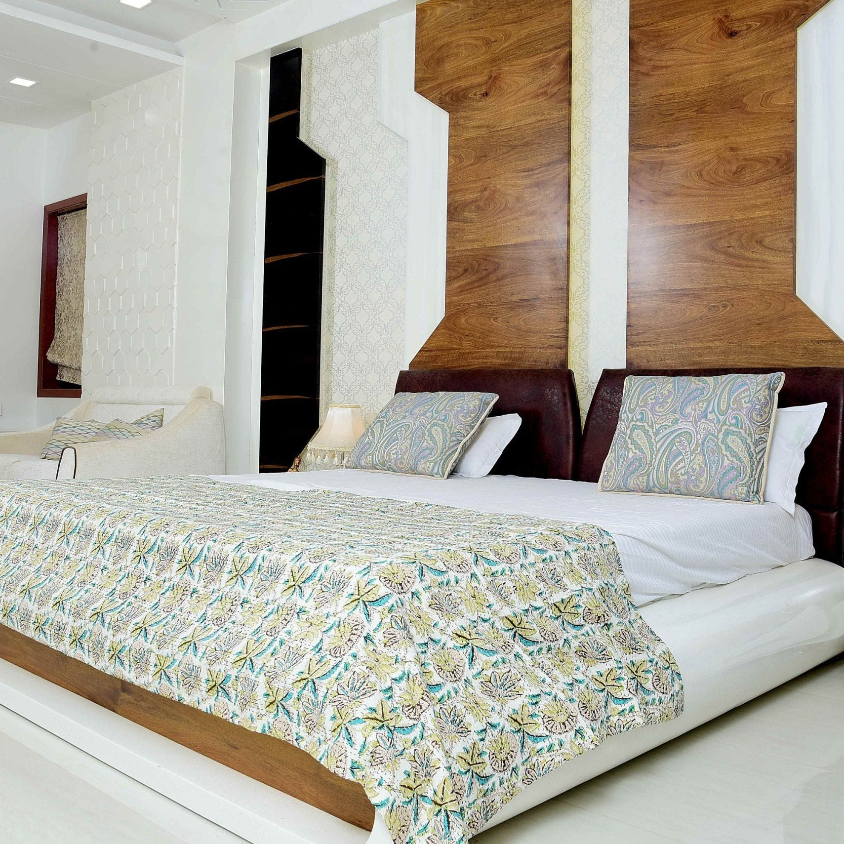 King-size Green Blossom Kantha quilt with floral patterns on a modern bed in a bright bedroom.